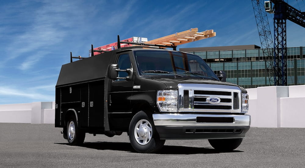 Black 2026 Ford E-Series Cutaway driving on a parking lot.