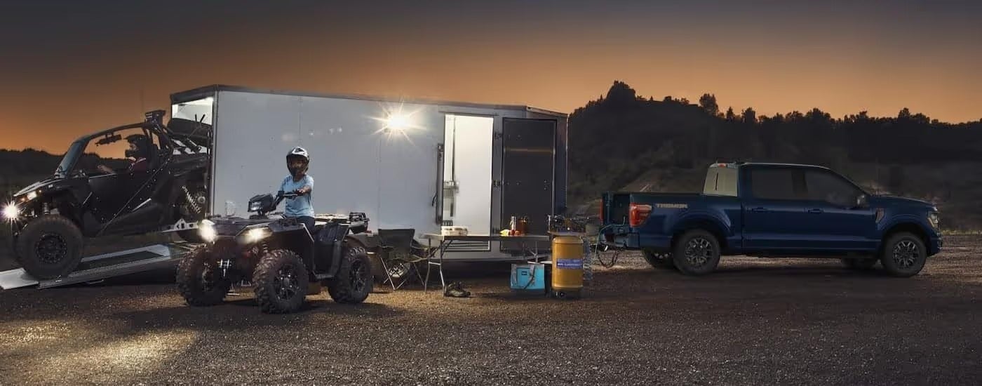 Blue 2025 Ford F-150 Tremor with an enclosed trailer