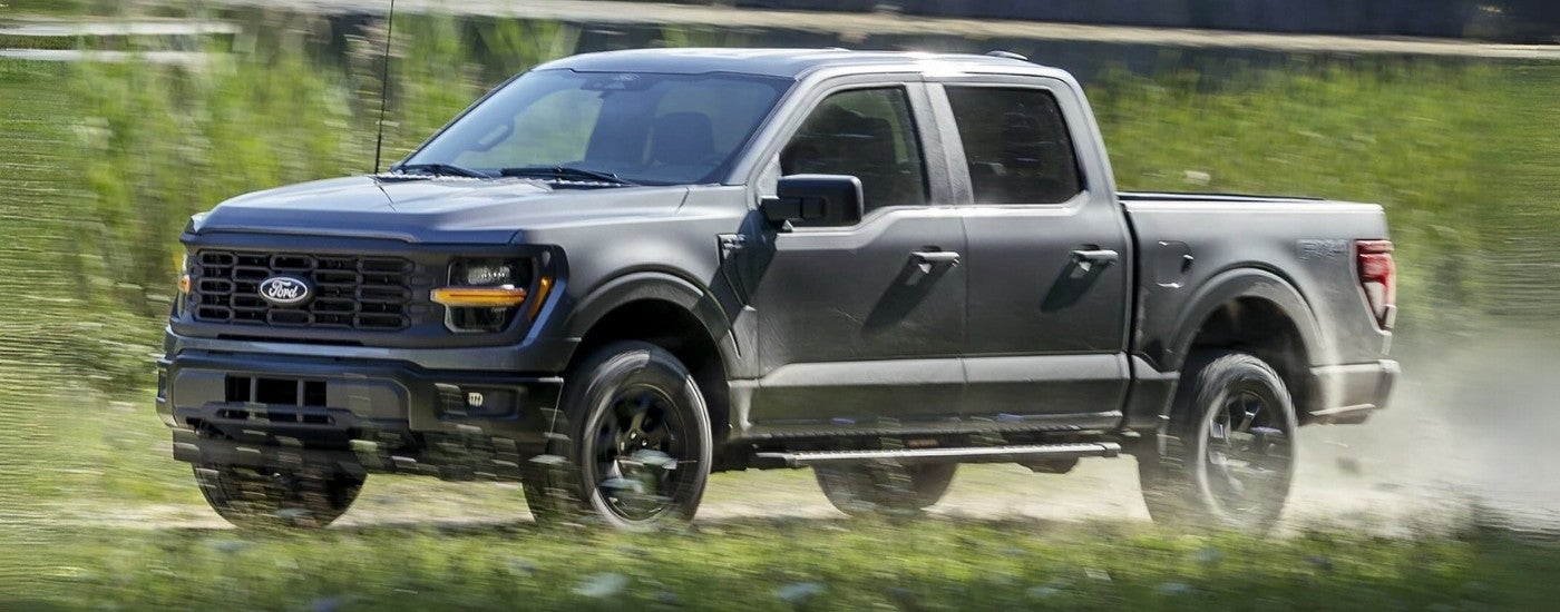 A grey 2025 Ford F-150 FX4 driving on a dusty trail