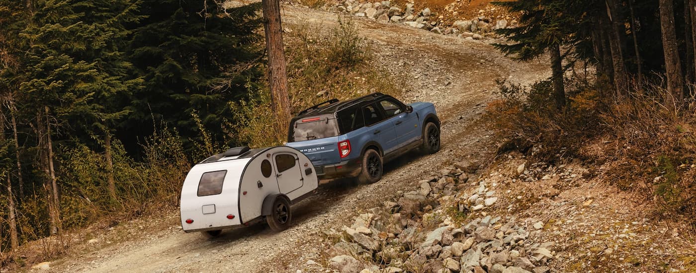Grey 2026 Ford Bronco Sport towing a camper off-road.