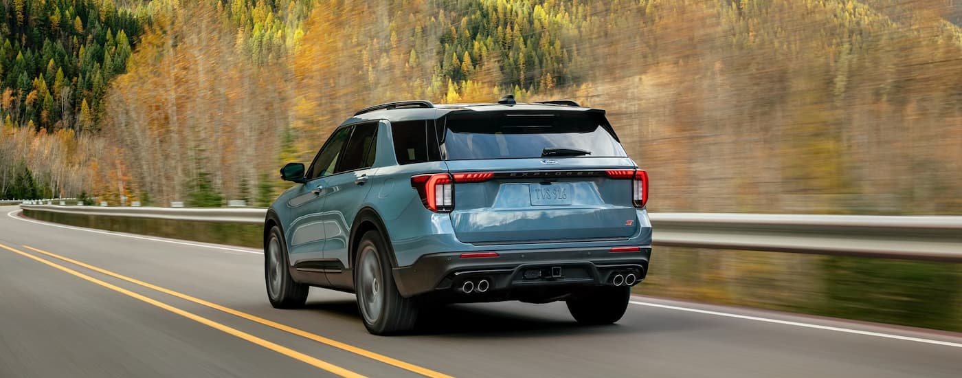 Rear of a blue 2026 Ford Explorer driving down a road.