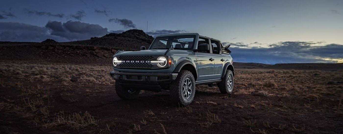 Blue 2025 Ford Bronco Badlands for sale parked off-road at dusk.