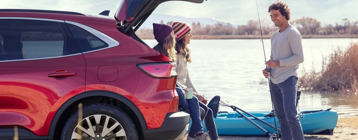 People fishing near a red 2022 Ford Escape.