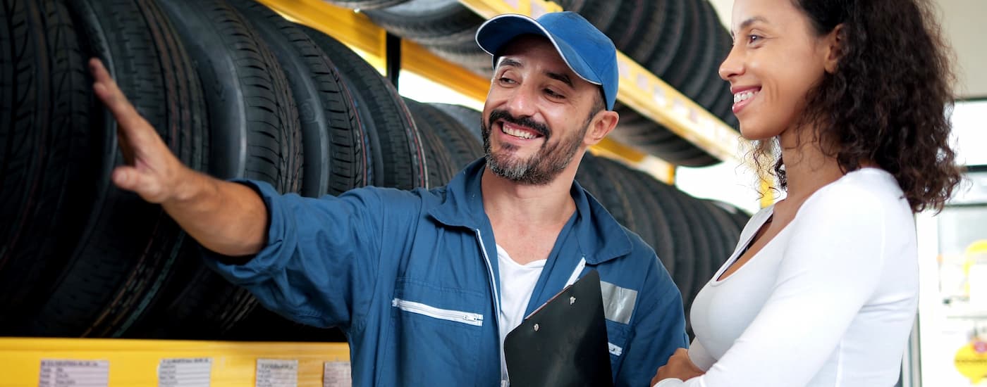 Mechanic helping a customer choose tires for their car